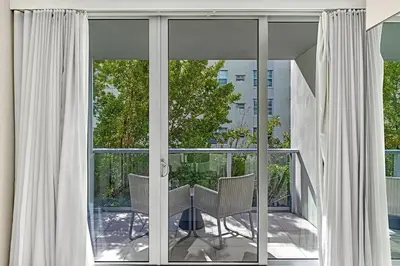 a balcony with glass doors and a table and chairs at Double Queen Room-Hosted by Sweetstay in Miami Beach