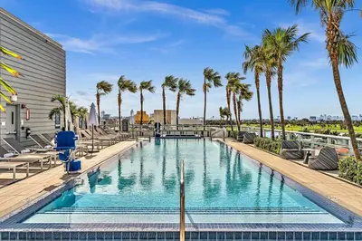 a swimming pool with palm trees and a building at Double Queen Room-Hosted by Sweetstay in Miami Beach