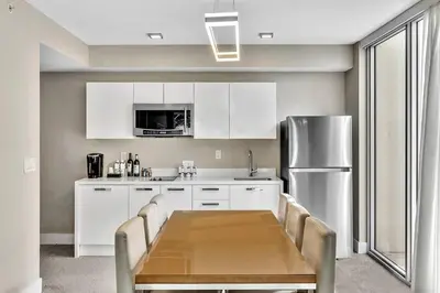 a kitchen with a table and a stainless steel refrigerator at King Suite balcony water views-Hosted by Sweetstay in Miami Beach