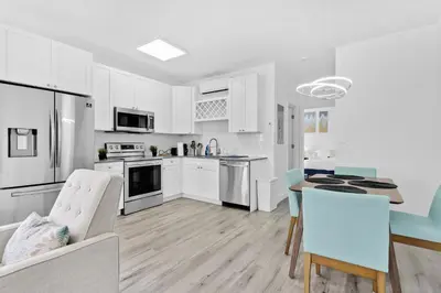 a kitchen with white cabinets and a table and chairs at Beautiful Apt 5min walking Design District apt 1 in Miami