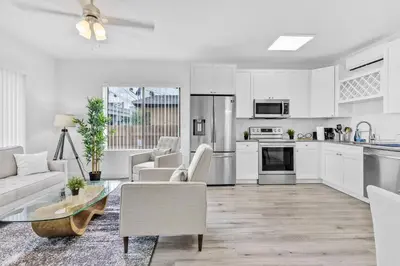 a kitchen and living room with white cabinets at Beautiful Apt 5min walking Design District apt 1 in Miami