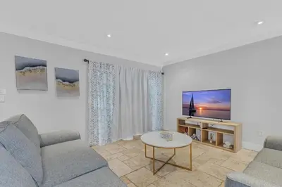 a living room with a couch and a tv at Tropical Oasis with Heated Pool and BBQ in Tamiami