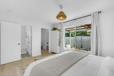 a bedroom with a white bed and a large window at Modern 3 Bedroom GetAway with Parking in Coral Gables in Miami