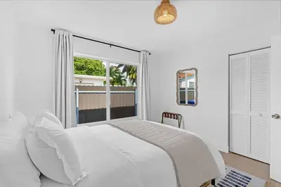 a bedroom with a white bed and a window at Modern 3 Bedroom GetAway with Parking in Coral Gables in Miami