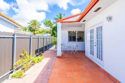 a white house with a fence and a patio at Modern 3 Bedroom GetAway with Parking in Coral Gables in Miami
