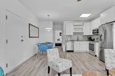 a kitchen with white cabinets and a table and chairs at Wonderful 6ppl Apt 5 min walking Design District 2 in Miami