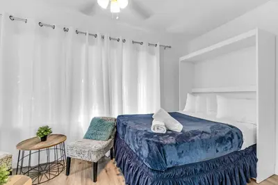 a bedroom with a bed and a table and a chair at Wonderful 6ppl Apt 5 min walking Design District 2 in Miami