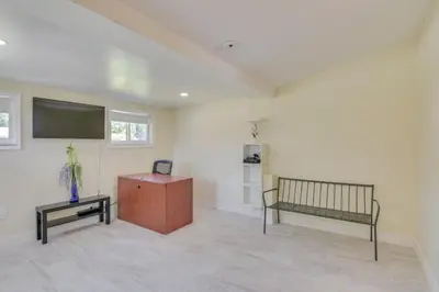 a living room with a bench and a flat screen tv at Miami Gardens Apt 5 Miles to Hard Rock Stadium in Miami Gardens