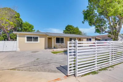 a house with a white fence in front of it at Miami Gardens Apt 5 Miles to Hard Rock Stadium in Miami Gardens
