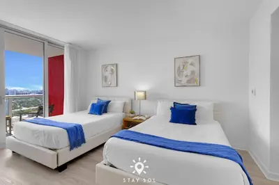 two beds in a room with a window at Beautiful Studio Amazing View Balcony in Hallandale Beach