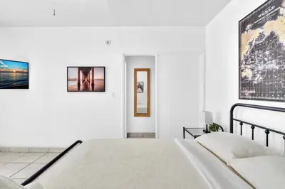 a white bedroom with a bed and a map on the wall at Downtown Hollywood Beach Blvd Studio Getaway in Hollywood