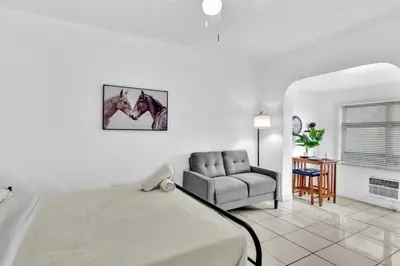 a bedroom with a bed and a couch and a chair at Downtown Hollywood Beach Blvd Studio Getaway in Hollywood