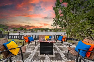 a patio with chairs and a table with a sunset at Lakefront Retreat Perfect for Family Fun in Miami