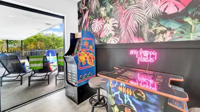 a room with a pinball machine and a table at Lakefront Retreat Perfect for Family Fun in Miami
