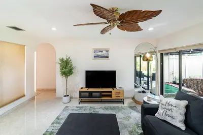 a living room with a tv and a ceiling fan at Charming 2BR Waterfront House in Fort Lauderdale