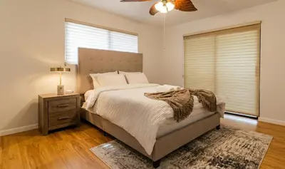 a bedroom with a bed and a nightstand and a window at Charming 2BR Waterfront House in Fort Lauderdale