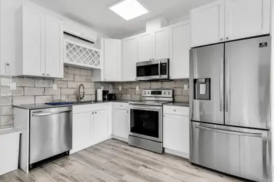 a kitchen with white cabinets and stainless steel appliances at Quiet Bright Apt 5min walking to Design District apt 6 in Miami