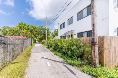 an empty street in front of a white building at Stylish Lux Apt 5 min walking to Design District apt 7 in Miami