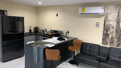 a kitchen with a counter and a bar with chairs at Ocean View Habana in Hialeah