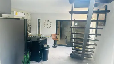 a living room with a spiral staircase and a desk at Ocean View Habana in Hialeah