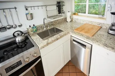 a kitchen counter with a sink and a stove at Miami Pool Cottage, tropical garden paradise in Miami