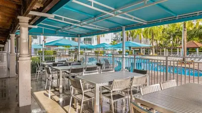 a patio with tables and chairs next to a swimming pool at Marriott Villas at Doral 2BD sleeps 8 in Miami