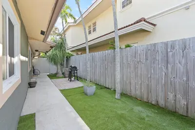 a backyard with a wooden fence and grass at Weekly Discounts 10 min to Beach by TilahStays in Fort Lauderdale