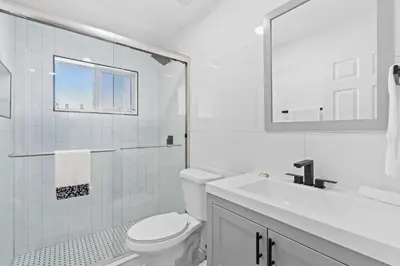 a white bathroom with a toilet and a sink at Weekly Discounts 10 min to Beach by TilahStays in Fort Lauderdale