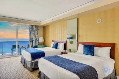 two beds in a hotel room with a view of the ocean at Deluxe Studio Ocean View Premium Amenities in Sunny Isles Beach