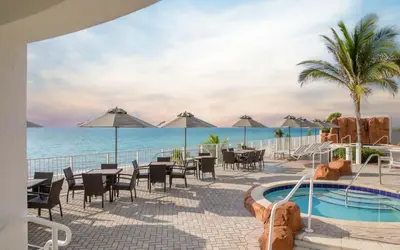 a resort with a pool and tables and chairs at Deluxe Studio Ocean View Premium Amenities in Sunny Isles Beach