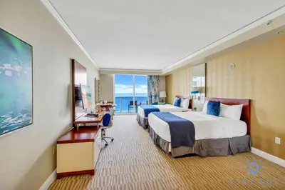 a hotel room with two beds and a balcony at Deluxe Studio Ocean View Premium Amenities in Sunny Isles Beach