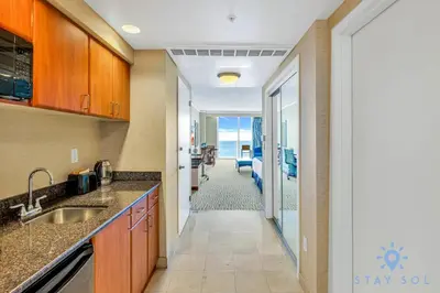 a kitchen with a sink and a door leading to a hallway at Ocean View Luxurious Studio Premium Amenities in Sunny Isles Beach