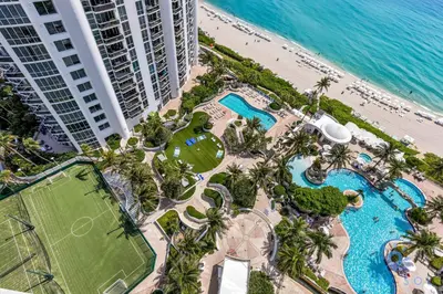an aerial view of a resort with a pool and the ocean at Ocean View Luxurious Studio Premium Amenities in Sunny Isles Beach