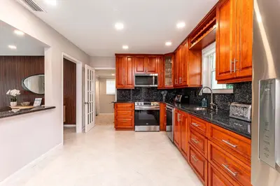 a kitchen with wooden cabinets and a stove top oven at Waterfront Pool & Amazing Location - WOW in Miami
