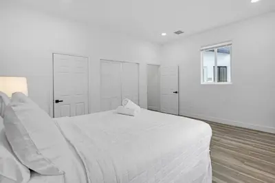 a white bedroom with a white bed and a window at Spacious Retreat with Green Areas 8 ppl in Miami
