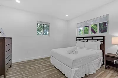 a white bedroom with a bed and two windows at Spacious Retreat with Green Areas 8 ppl in Miami