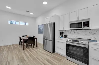 a kitchen with a table and a stainless steel refrigerator at Spacious Retreat with Green Areas 8 ppl in Miami