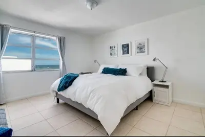 a white bedroom with a large bed and a window at 1101- Luxurious 1BR & 2 Bath with City & Ocean Views in Miami Beach