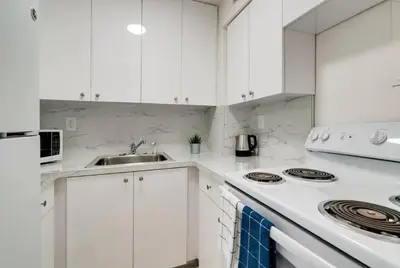 a white kitchen with white cabinets and a sink at 1101- Luxurious 1BR & 2 Bath with City & Ocean Views in Miami Beach