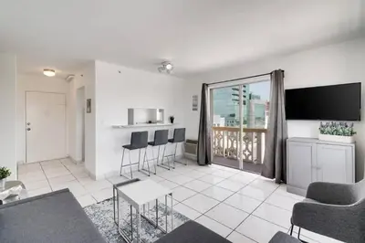 a living room with a table and chairs and a kitchen at 1106- 1BR & 1BA with Balcony, Stunning City & Ocean Views in Miami Beach