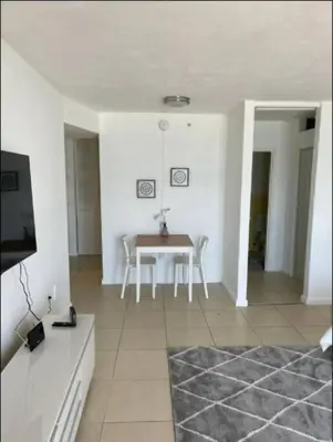 a living room with a table and chairs and a television at 1502- Seaside Serenity- 1BR & 1BA, Ocean Views in Miami Beach
