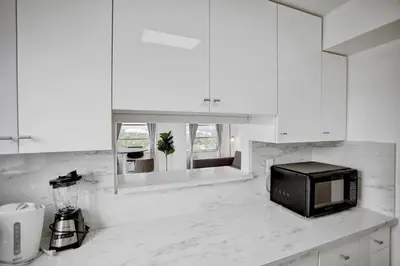 a kitchen with white cabinets and a black microwave at 1506- 1BR & 1BA Retreat with Stunning Intracoastal Views in Miami Beach