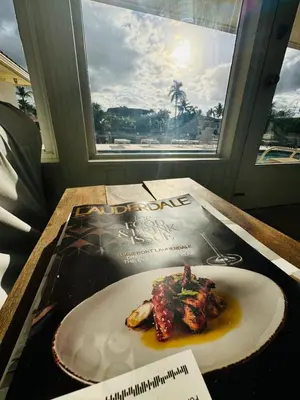 a plate of food on a table with a magazine at Fort Lauderdale Beach Oasis in Fort Lauderdale