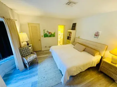 a bedroom with a large white bed and a chair at Fort Lauderdale Beach Oasis in Fort Lauderdale