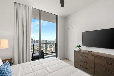a bedroom with a large window with a flat screen tv at 5108Great Penthouse, Bay view, in the heart of MIAMI in Miami