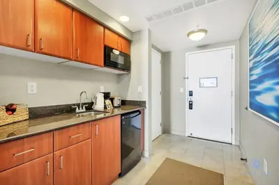 a kitchen with wooden cabinets and a sink at Luxury Bayfront Studio with Balcony Amazing Pool in Sunny Isles Beach
