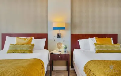 a hotel room with two beds and a table with a lamp at Luxury Bayfront Studio with Balcony Amazing Pool in Sunny Isles Beach