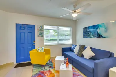 a living room with a blue couch and a yellow chair at 2 Mi to Ocean Dog-Friendly Hallandale Beach Condo in Hallandale Beach