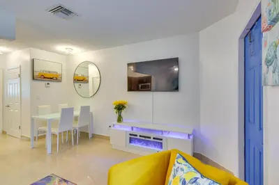 a living room with a table and a fireplace at 2 Mi to Ocean Dog-Friendly Hallandale Beach Condo in Hallandale Beach