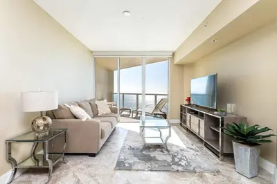 a living room with a couch and a tv at Beach Vibes & 30th Floor Ocean Views in Sunny Isles Beach